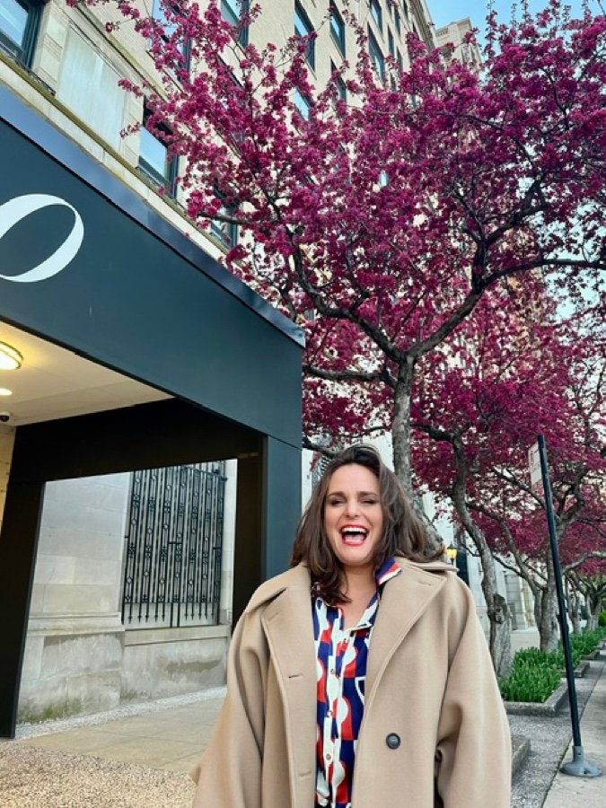 Courtenay Martire outside a Chicago building beneath spring blossom