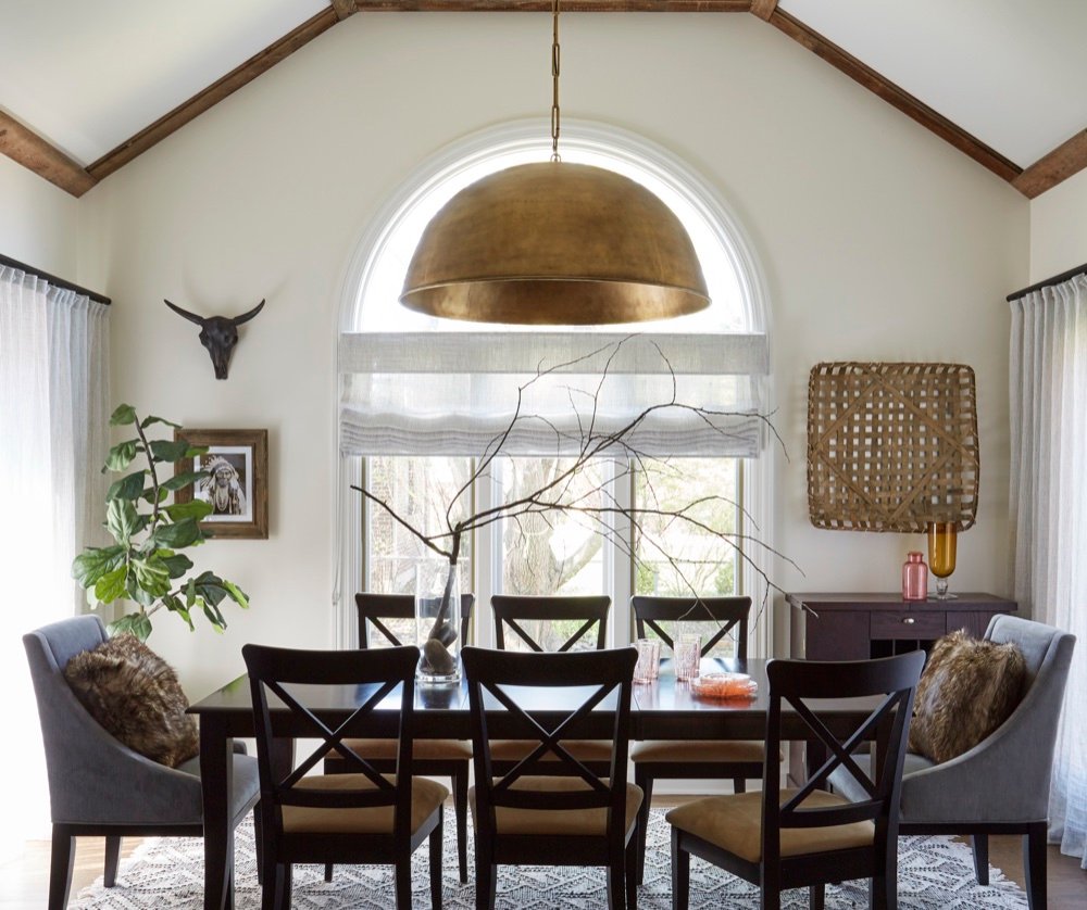 Dinette with black farm table, spindle end chairs, large brass dome pendant and barn wood ceiling accents, by Martire Custom Homes