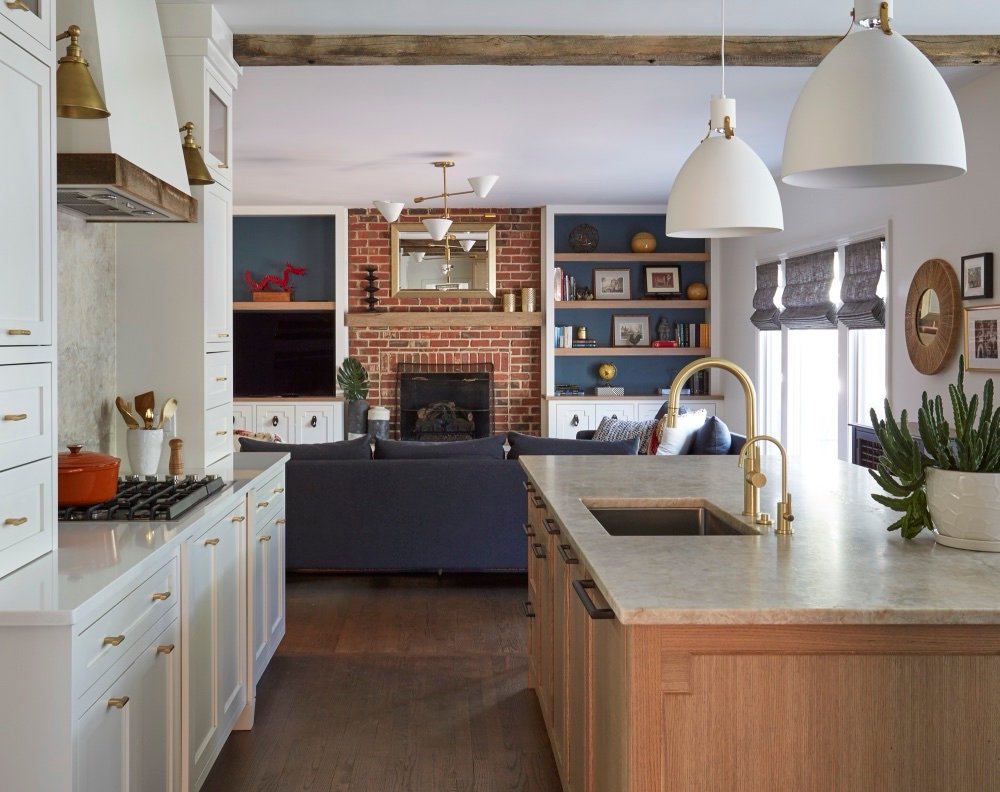 Open plan kitchen with oak island flowing into a family room with brick hearth, by Martire Custom Homes