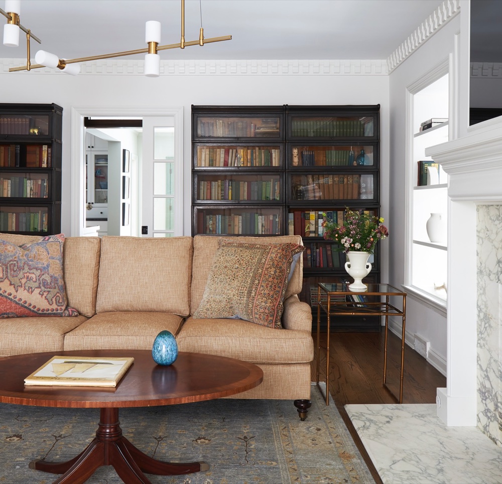 Living room with black barrister bookcases and tan sofa, luxury renovation and interior design by Martire Custom Homes