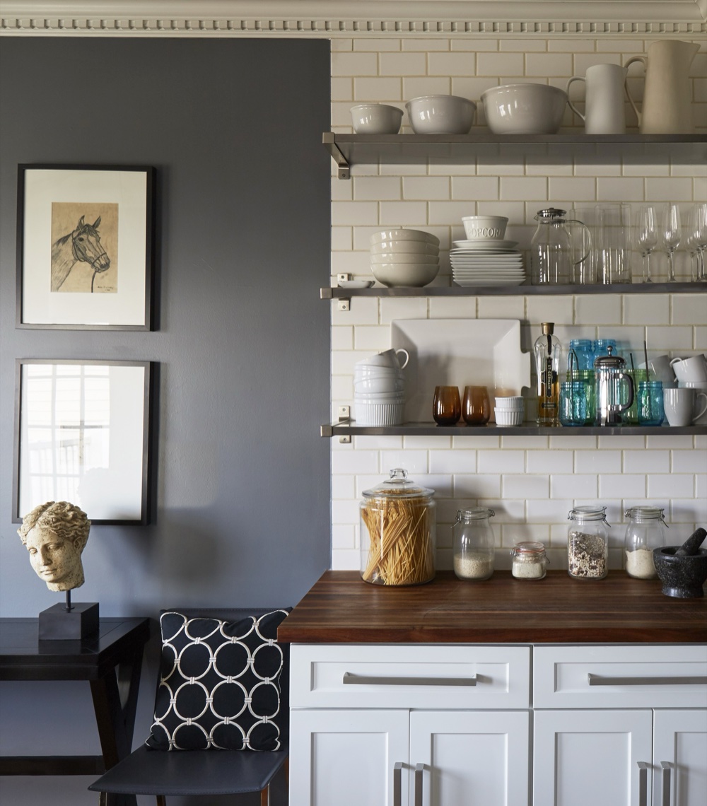 Kitchen with white shaker cabinetry, walnut butcher-block counters, stainless open shelving stacked with white ironstone and a cream subway tile backsplash, by Martire Custom Homes